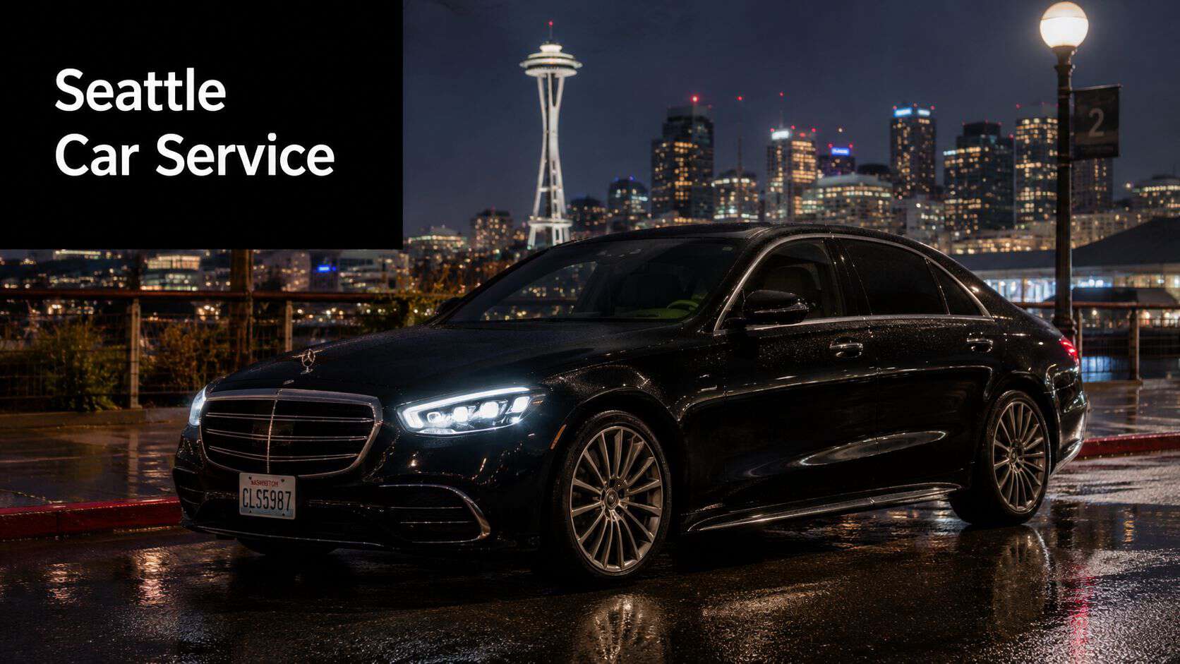 A black Mercedes-Benz sedan parked on a wet street at night in front of the Seattle skyline.