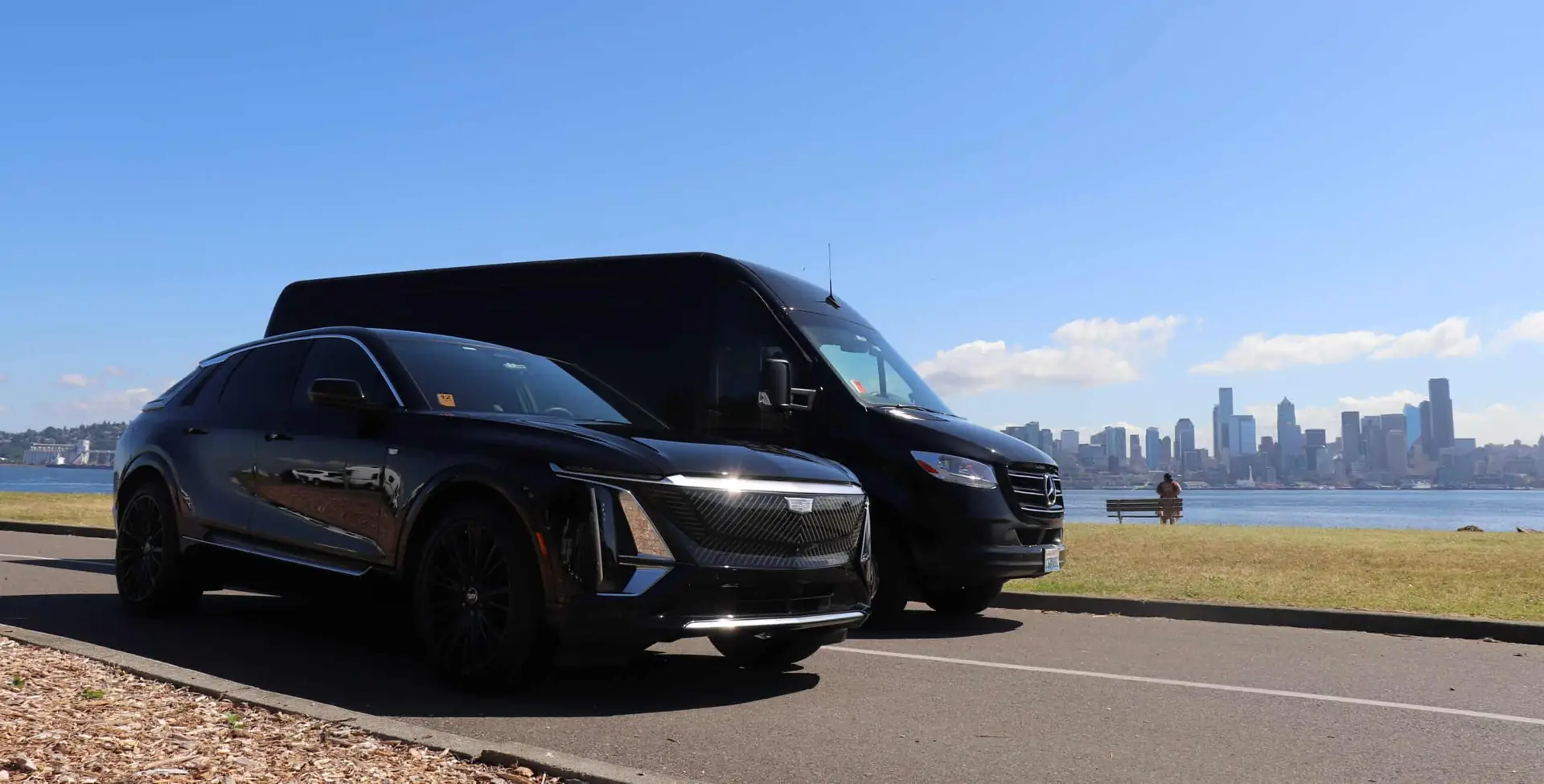 All Black Limo fleet: Cadillac SUV and Mercedes Sprinter with the Seattle skyline